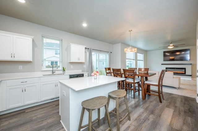 kitchen featuring white cabinets, decorative light fixtures, plenty of natural light, and sink