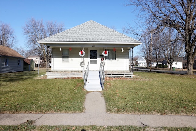 bungalow-style house featuring covered porch and a front lawn