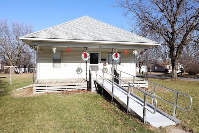 rear view of house with covered porch and a yard