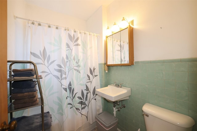 bathroom featuring walk in shower, sink, tile walls, and toilet