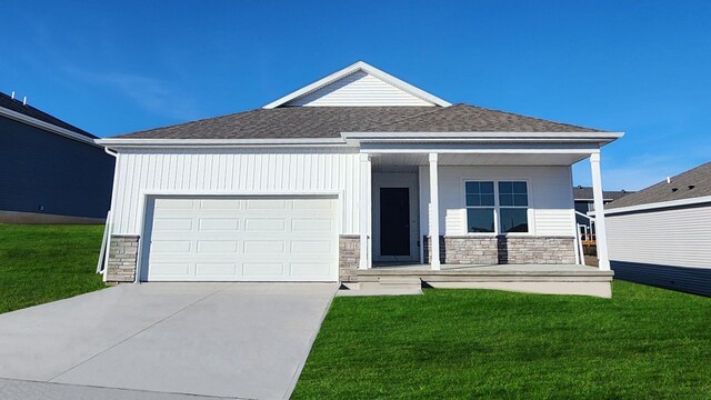 view of front facade with a garage, covered porch, and a front yard