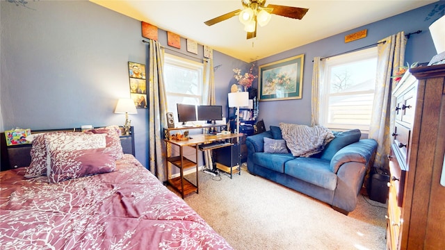 carpeted bedroom featuring ceiling fan and multiple windows