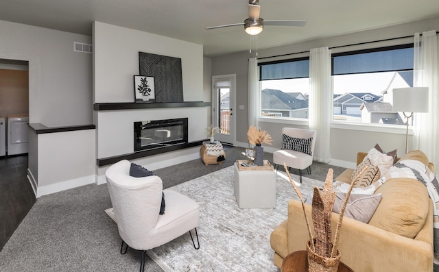 carpeted living room featuring washing machine and dryer and ceiling fan