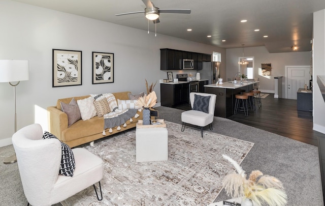 living room with ceiling fan, dark wood-type flooring, and sink