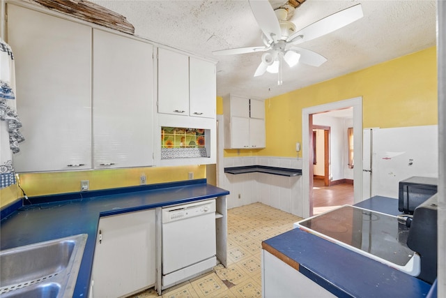 kitchen featuring dishwasher, ceiling fan, white cabinetry, and a textured ceiling