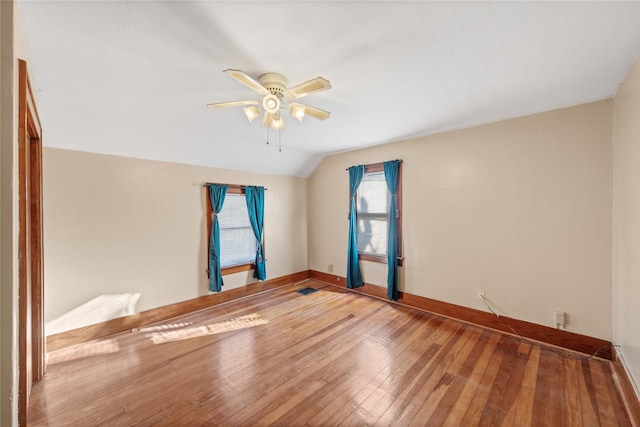 empty room featuring wood-type flooring, ceiling fan, and lofted ceiling