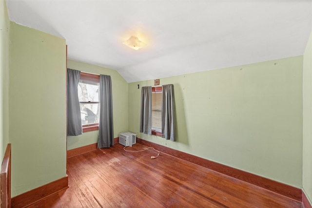 spare room with wood-type flooring and vaulted ceiling