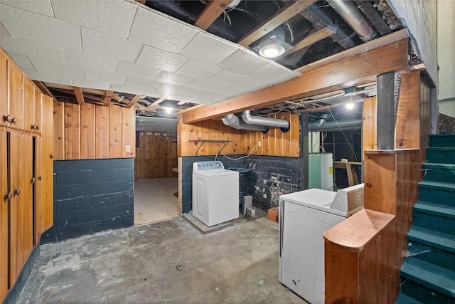 basement with wood walls, washer / clothes dryer, and water heater