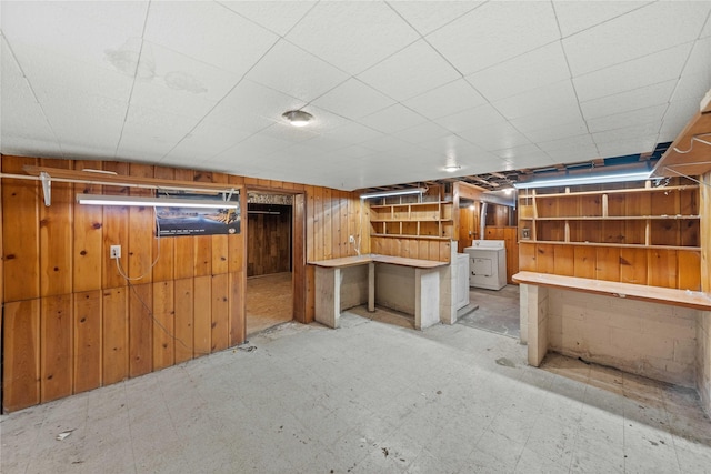 basement with washer / clothes dryer and wooden walls