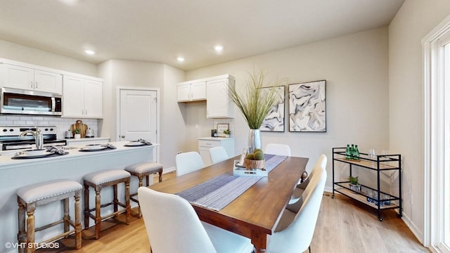 dining space with light hardwood / wood-style flooring and sink