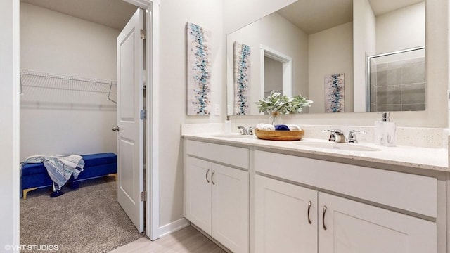 bathroom with walk in shower and vanity