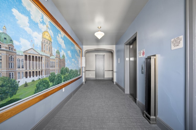 corridor featuring dark carpet and elevator