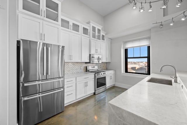 kitchen with white cabinets, light stone counters, sink, and appliances with stainless steel finishes