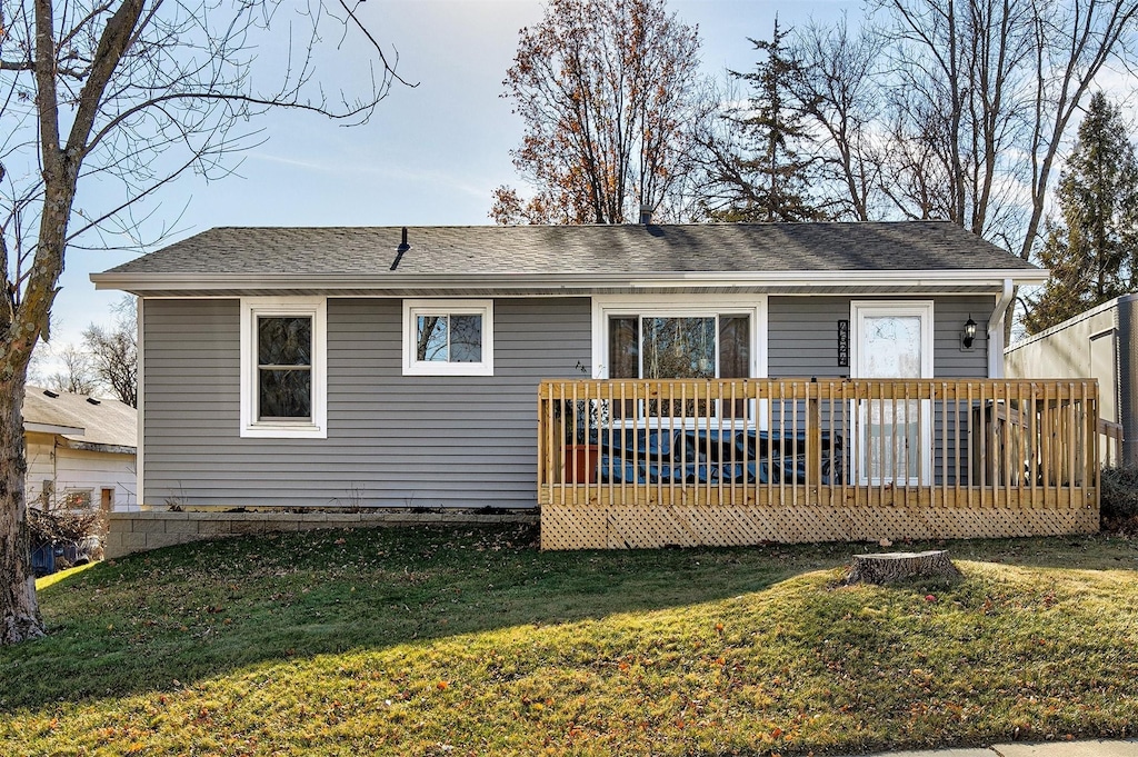 back of property with a lawn and a deck