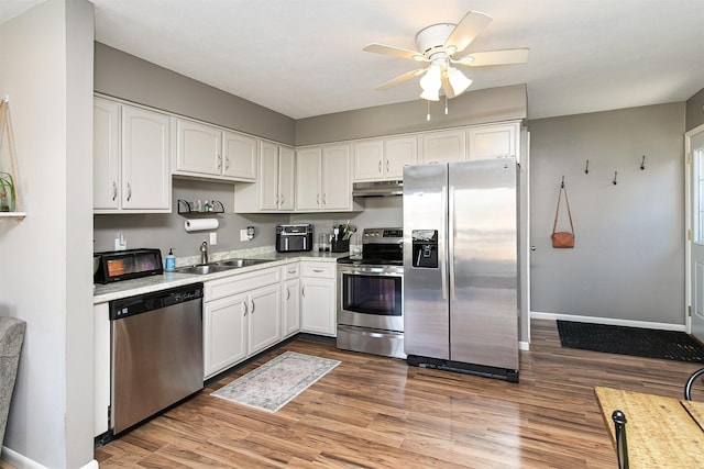 kitchen featuring white cabinets, hardwood / wood-style floors, stainless steel appliances, and sink