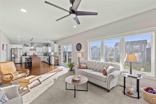 living room featuring ceiling fan and light hardwood / wood-style flooring