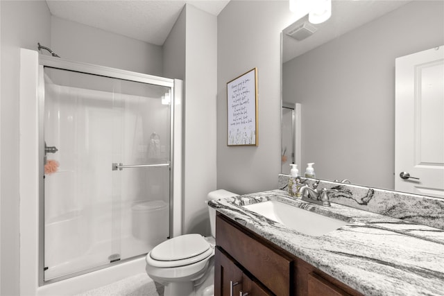 bathroom featuring toilet, vanity, a textured ceiling, and walk in shower