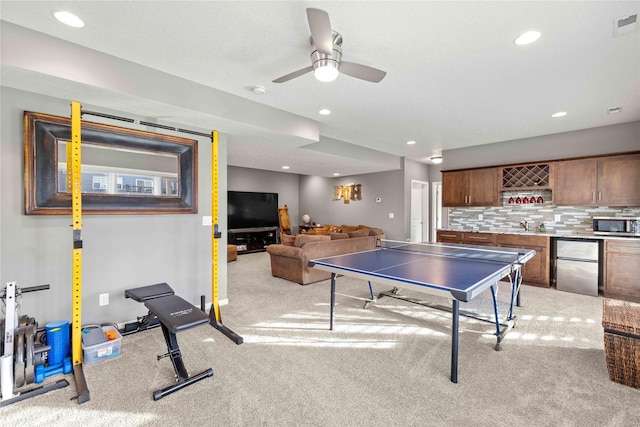 rec room with light carpet, a textured ceiling, and ceiling fan