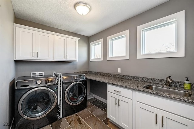 laundry area with sink, cabinets, a textured ceiling, and independent washer and dryer