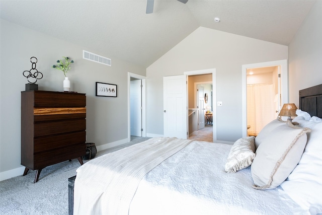 bedroom featuring light carpet, vaulted ceiling, ensuite bath, and ceiling fan