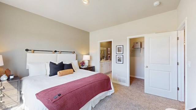 carpeted bedroom with connected bathroom, a spacious closet, and a closet