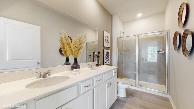 bathroom with hardwood / wood-style flooring, vanity, toilet, and walk in shower