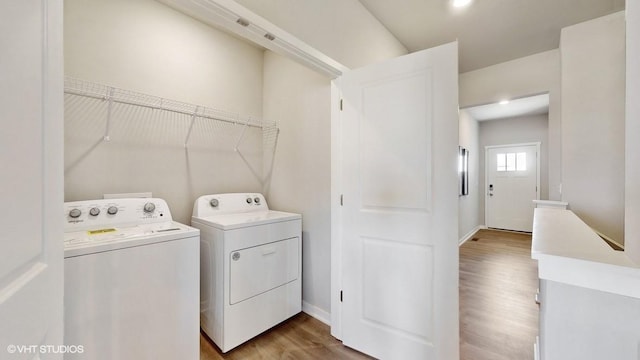 clothes washing area featuring hardwood / wood-style flooring and washer and dryer