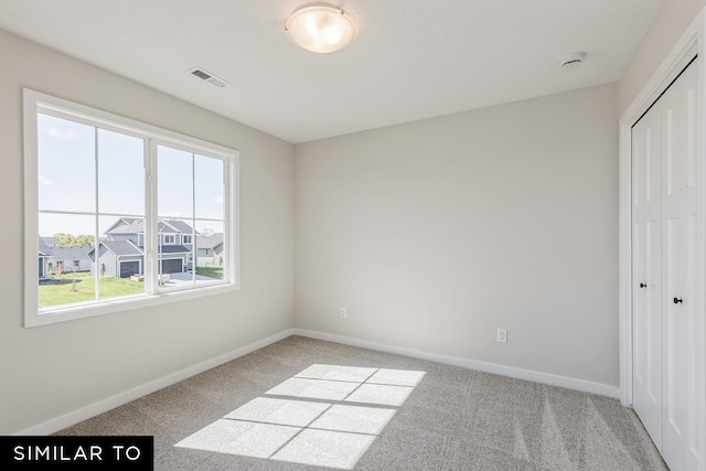 unfurnished bedroom featuring light carpet and a closet