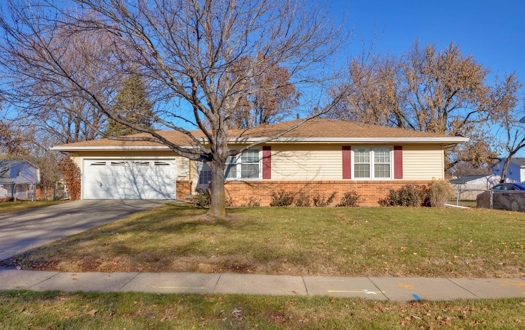 ranch-style home with a garage and a front lawn