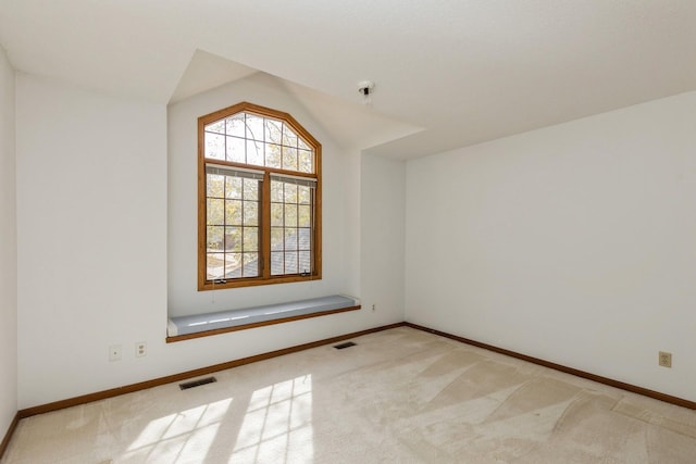 additional living space with light colored carpet and vaulted ceiling