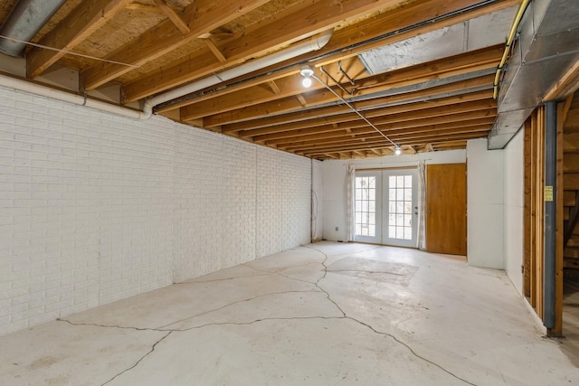 basement featuring french doors and brick wall