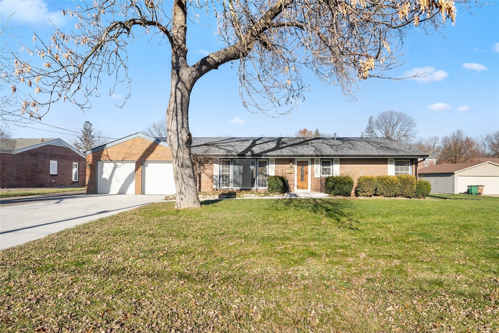 ranch-style home featuring a garage and a front lawn