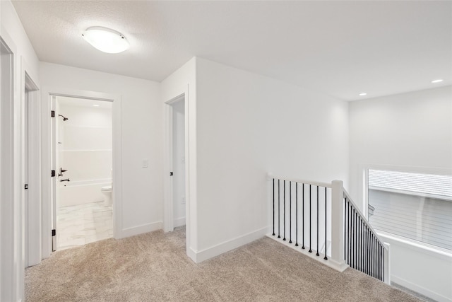 hallway featuring light colored carpet