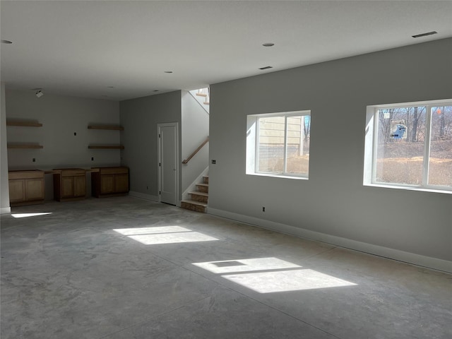 unfurnished living room with stairs, concrete floors, visible vents, and baseboards