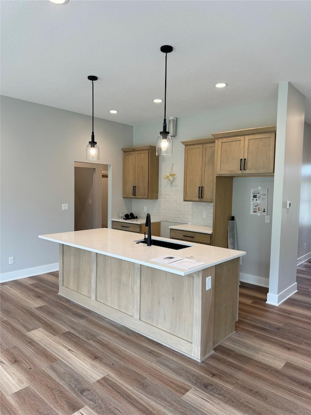 203 Hudson Ave, Van Meter, IA 50261 - kitchen featuring a sink, dark wood-style floors, recessed lighting, baseboards, and an island with sink