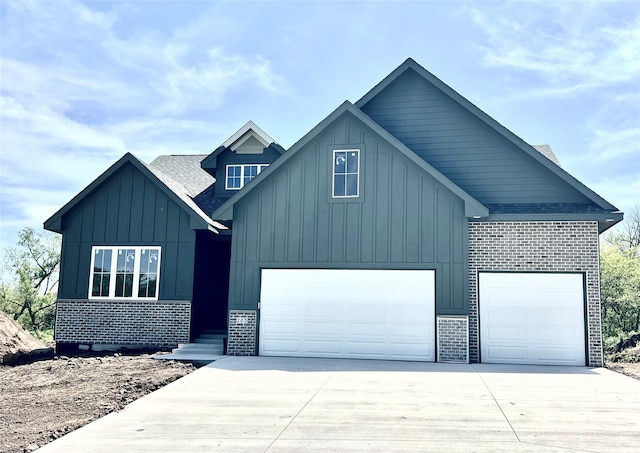 203 Hudson Ave, Van Meter, IA 50261 - modern farmhouse featuring board and batten siding, concrete driveway, brick siding, a garage, and a shingled roof