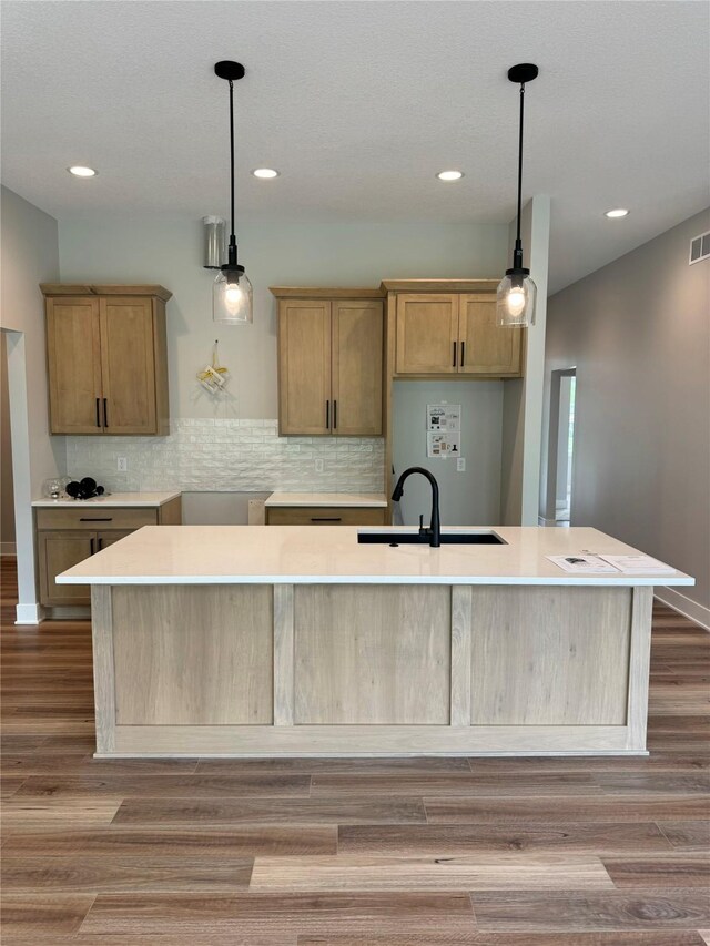 203 Hudson Ave, Van Meter, IA 50261 - kitchen with a sink, backsplash, an island with sink, recessed lighting, and wood finished floors