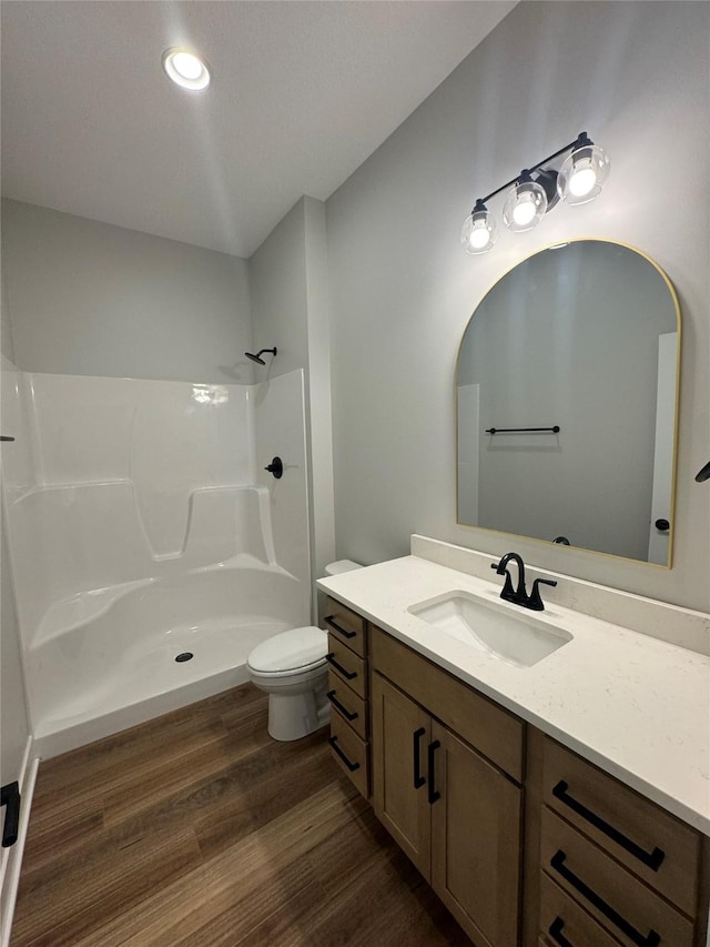 203 Hudson Ave, Van Meter, IA 50261 - bathroom featuring vanity, wood finished floors, a shower, toilet, and recessed lighting