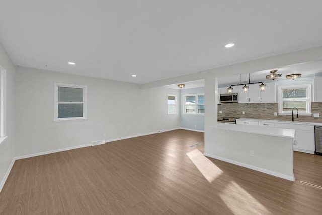 unfurnished living room with hardwood / wood-style floors and sink