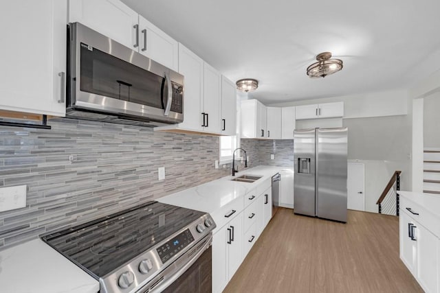 kitchen with white cabinets, sink, appliances with stainless steel finishes, and tasteful backsplash