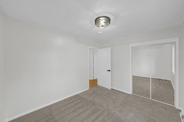 unfurnished bedroom with carpet flooring and a closet