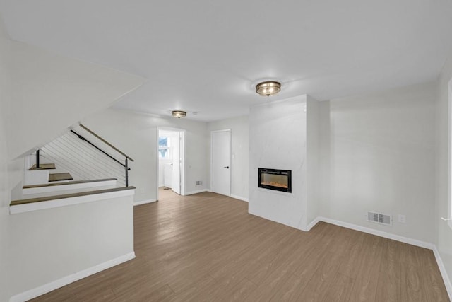 unfurnished living room featuring hardwood / wood-style floors and a large fireplace