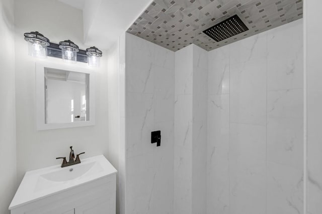 bathroom featuring a tile shower and vanity