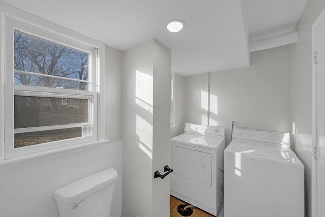 laundry area featuring washer and clothes dryer and tile walls