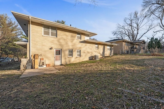 rear view of property featuring a yard, a patio, and central air condition unit