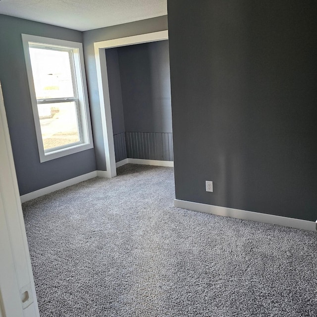 carpeted spare room featuring a textured ceiling