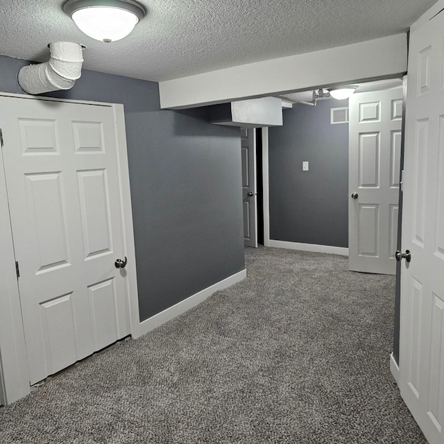 basement featuring a textured ceiling and carpet floors