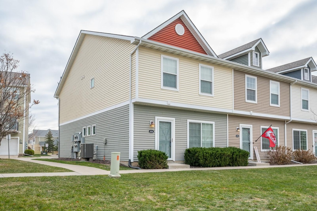 townhome / multi-family property featuring central AC and a front lawn