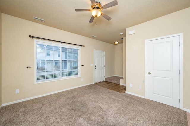 carpeted empty room featuring ceiling fan and a textured ceiling