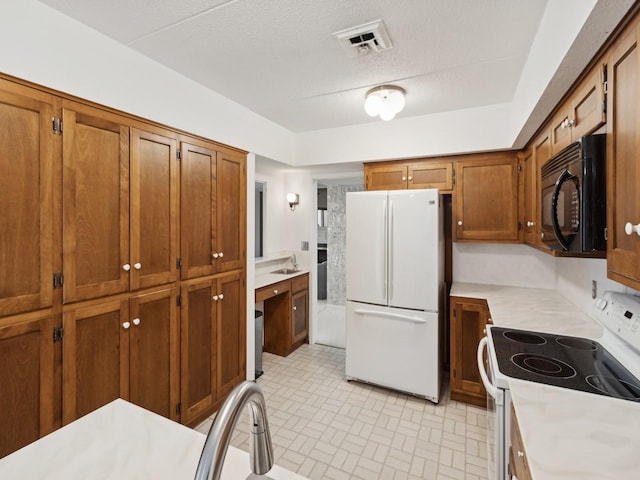 kitchen with white appliances and a textured ceiling